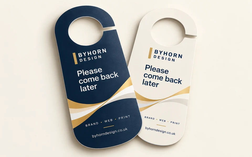 Illustrative Byhorn door hangers mockup on light cream; 70 × 200mm round door hanger · 350gsm gloss · double-sided · no lamination